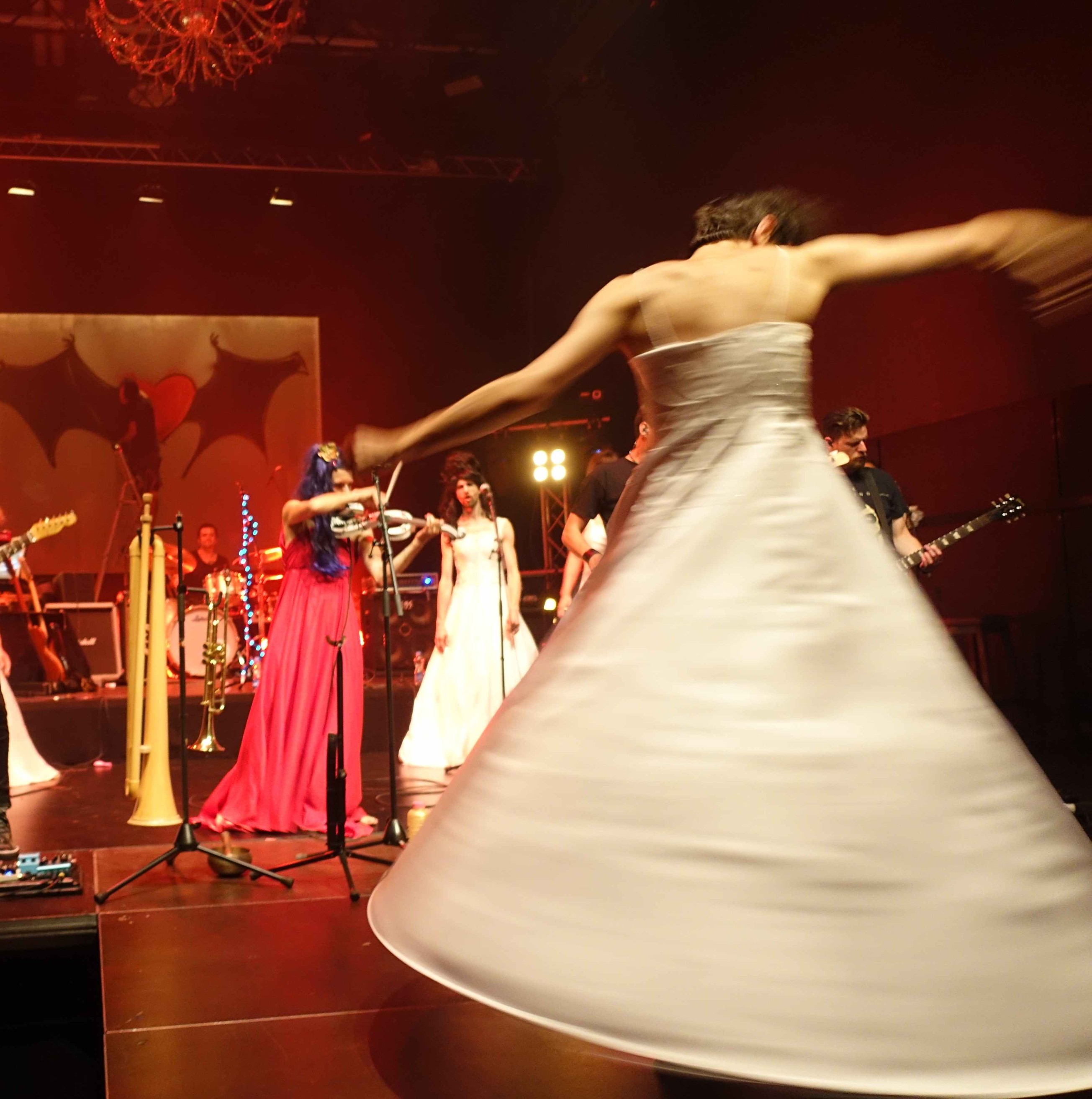 Roylesque is twirling fast on stage, their white wedding dress forming a dynamic cone, their arms outstretched.